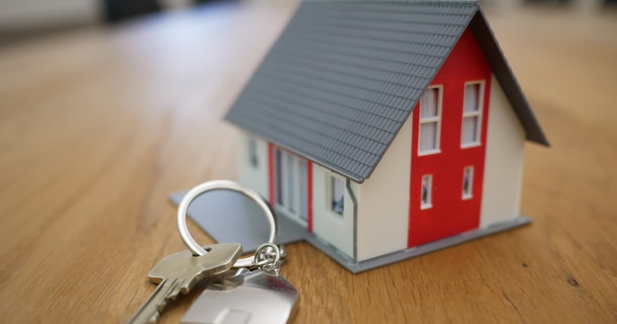 Miniature house model with keys on a wooden table