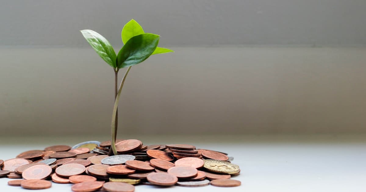 Piggy bank next to a stack of bills representing savings and debt balance